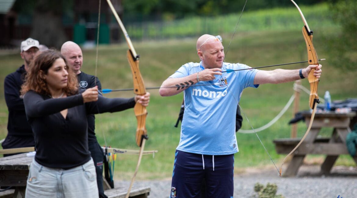 Woman and man pictured with archer's bows and arrows