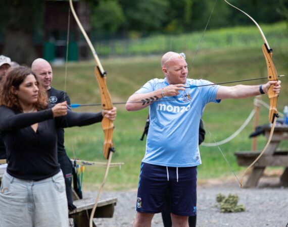 Woman and man pictured with archer's bows and arrows
