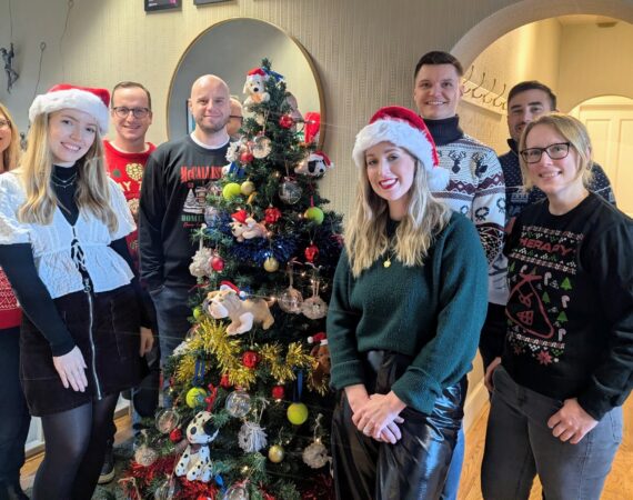 R&Co team pictured next to the Speranta Shelter-themed Christmas tree, decorated with dog baubles and tennis balls