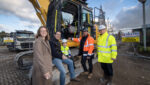 Family photographed beside a digger at Miller Homes