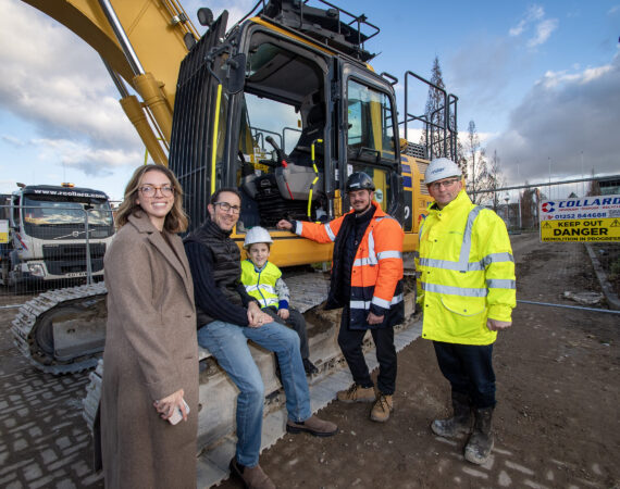 Family photographed beside a digger at Miller Homes