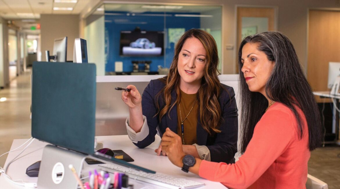 Two women working in professional services pictured looking at a computer monitor