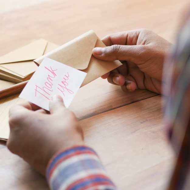 Someone opening a note that says thank you