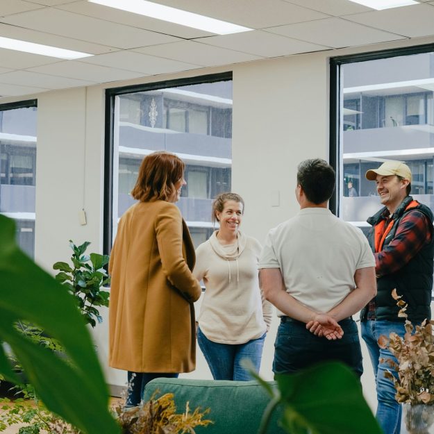 four people having a discussion in a office