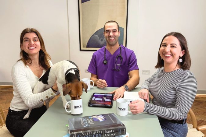 The Ronda.vet team pictured with dog drinking out of a mug